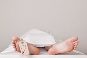 Covered dead body of a person in the morgue with a tag attached to the toe